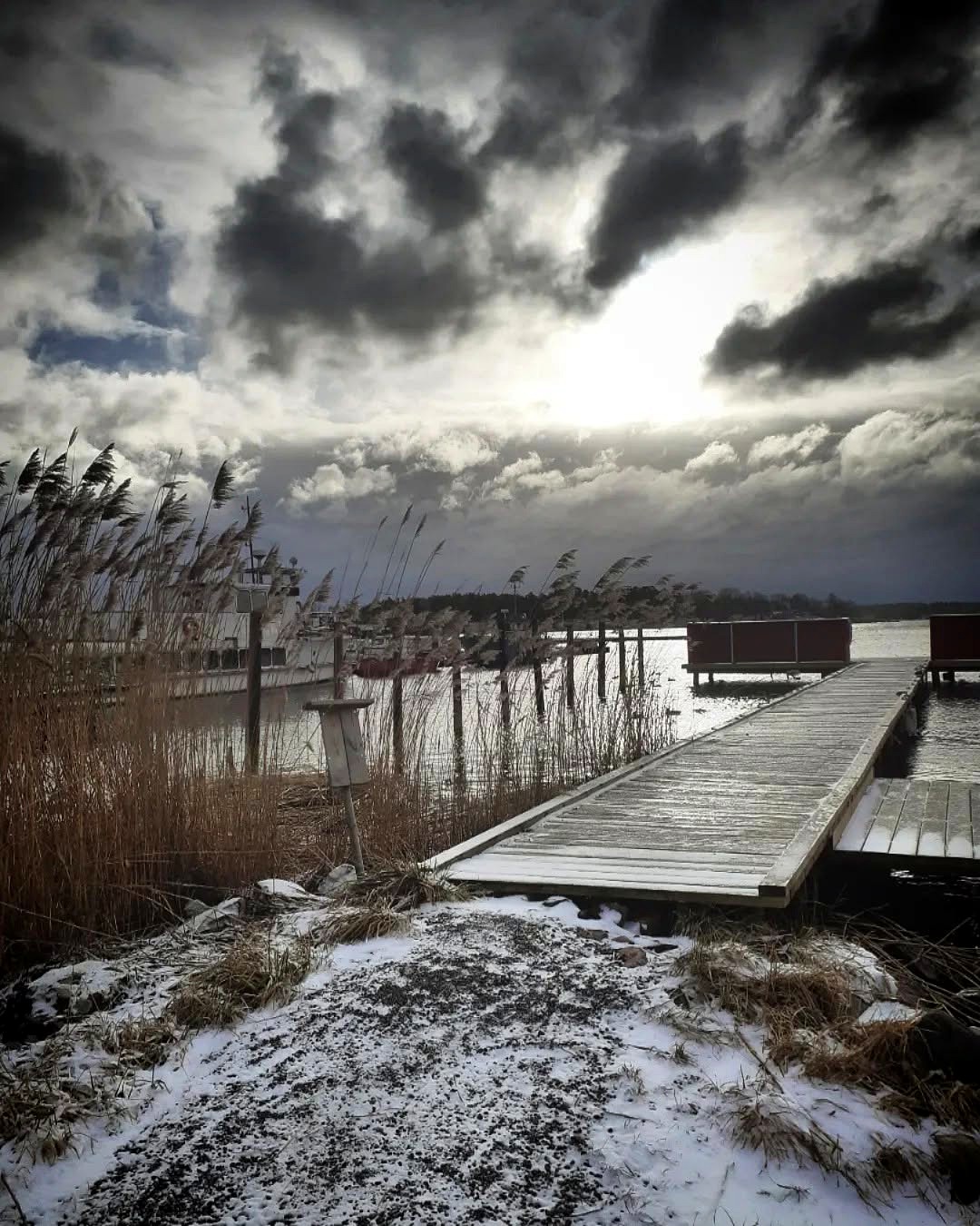 Snötäckt brygga i dramatiskt vinterljus
